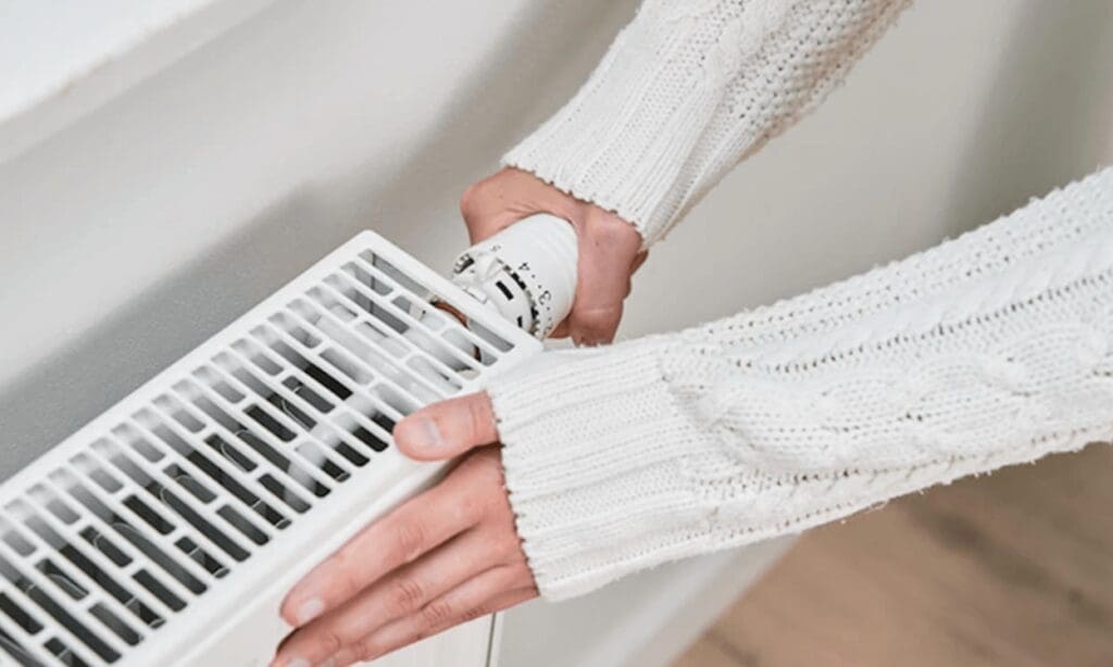 Woman checking radiator temperature