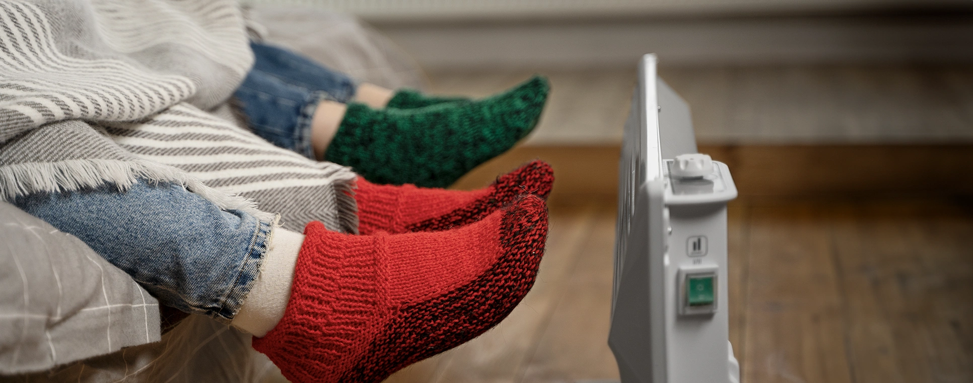 People warming their feet in front of electric heater